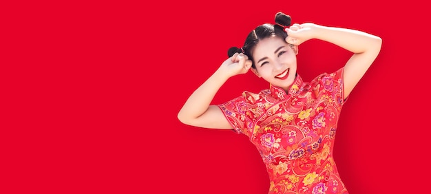 Foto mulher asiática em ação fofa de cheongsam vermelho no tamanho de banner longo de fundo vermelho (incluir caminho)