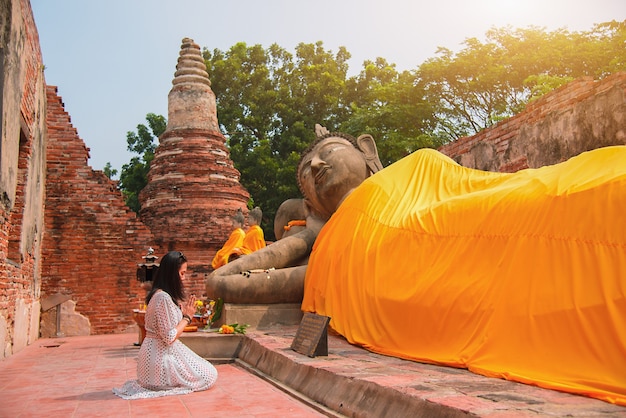 Mulher asiática em homenagem à estátua de Buda em Ayutthaya, Tailândia.