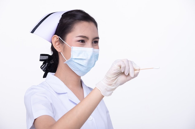 Mulher asiática enfermeira uniforme branco com máscara protetora segurando cotonete para verificar se há coronavírus ou covid-19 no nariz sobre fundo branco isolado cópia espaço