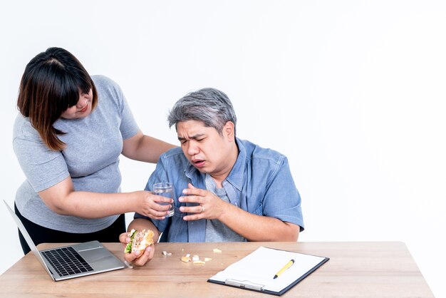 Mulher asiática entregando um copo d'água para o marido isolado