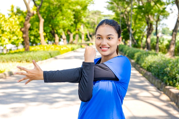 Mulher asiática esticando os braços antes de correr