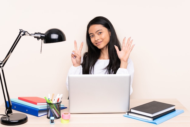 Mulher asiática estudante em um local de trabalho com um laptop isolado