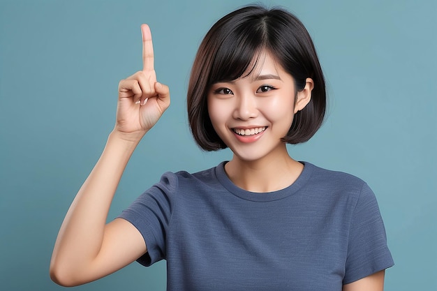 Foto mulher asiática excitada com cabelo escuro curto lançando uma ideia levantando o dedo em gesto eureka e sorrindo