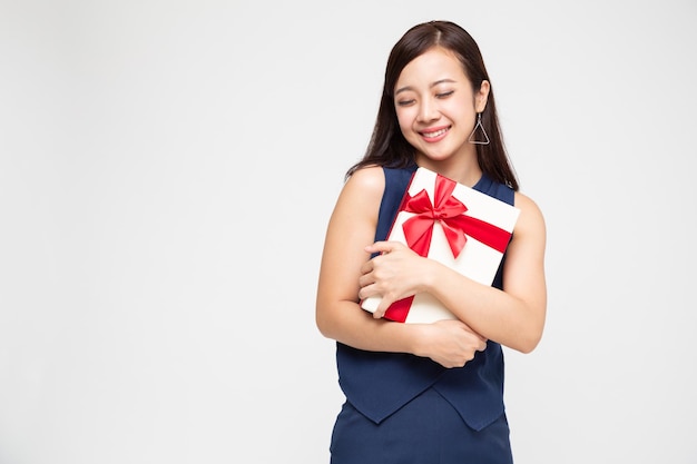 Mulher asiática feliz abraçando uma caixa de presente isolada no fundo branco