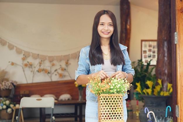 Mulher asiática feliz segurando uma cafeteria segurando flores