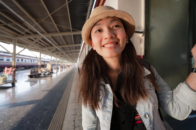 Mulher asiática feliz viaja de trem tradicional na tailândia