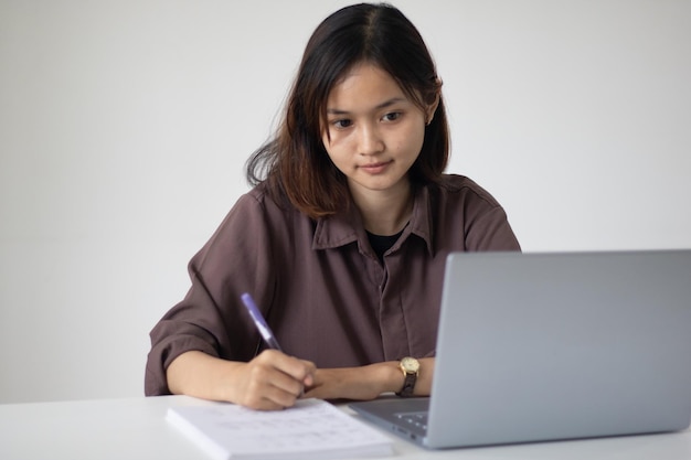 Mulher asiática focada usando laptop no escritório durante o dia