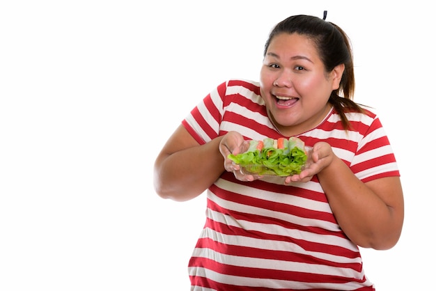 Mulher asiática gorda e feliz sorrindo enquanto segura alface