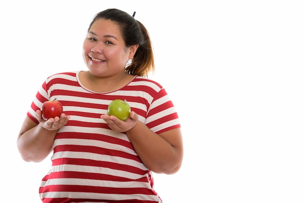 Mulher asiática gorda e feliz sorrindo enquanto segura maçãs