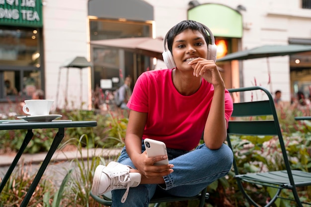 Mulher asiática hipster usando fones de ouvido sem fio ouvindo música na rua