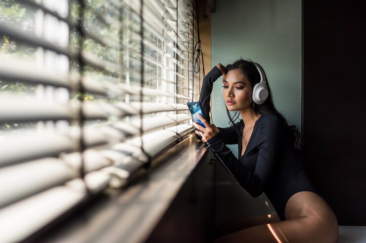 Foto mulher asiática jogando smartphone pela janela