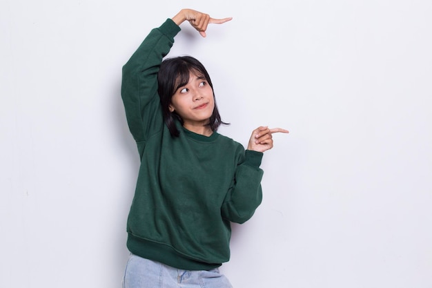 Mulher asiática jovem feliz apontando com os dedos para diferentes direções, isoladas no fundo branco