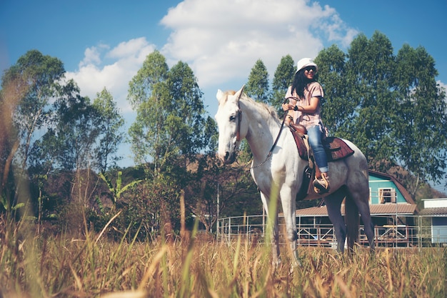 Mulher asiática, montando, um, cavalo