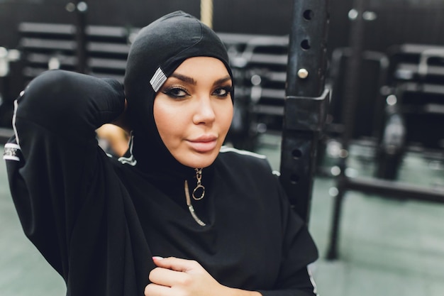 Foto mulher asiática muçulmana de hijab se exercitando em um ginásio