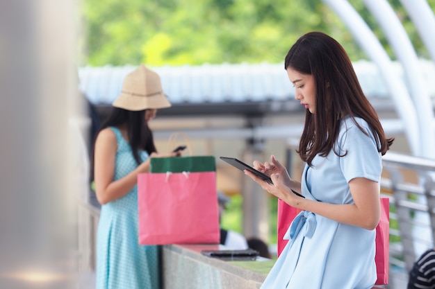 Mulher asiática nova feliz com saco de compras.