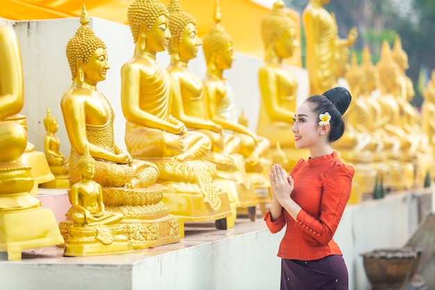 Mulher asiática para pagar o respeito à estátua da Buda em Tailândia.