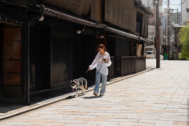 Mulher asiática passeando com seu cachorro husky ao ar livre