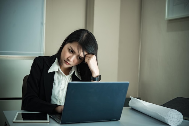 Mulher asiática que trabalha no escritóriojovem empresária estressada por sobrecarga de trabalho com muitos arquivos na mesaTailândia pessoas pensando em algo