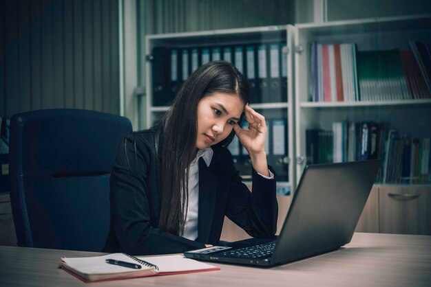 Mulher asiática que trabalha no escritóriojovem empresária estressada por sobrecarga de trabalho com muitos arquivos na mesatailândia pessoas pensando em algo