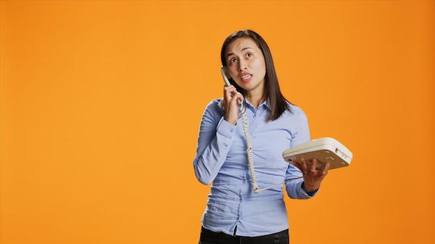 Foto mulher asiática realiza chamada remota em seu telefone fixo