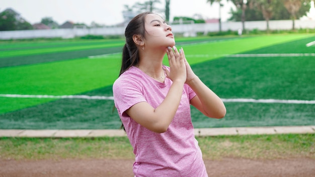 Mulher asiática se aquecendo antes de correr