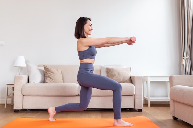 Mulher asiática se exercita com halteres em casa mulher feliz fazendo exercícios de braço usando halteres