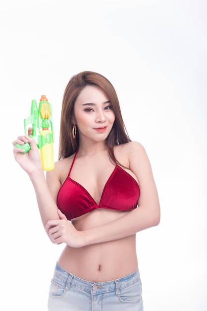 Mulher asiática segura arma de água e sorri no dia do festival de Songkran na Tailândia isolou o fundo branco