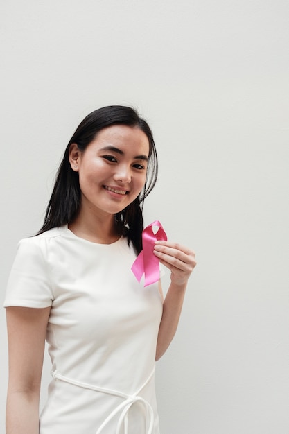 Mulher asiática segurando a fita rosa, consciência de câncer de mama rosa de outubro