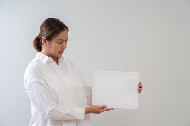 Mulher asiática segurando copyspace de publicidade de quadro branco