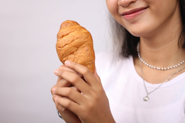 Mulher asiática segurando pão isolado no fundo branco