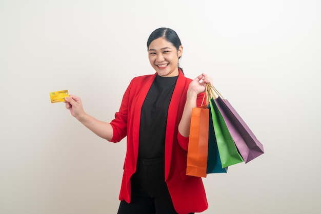 Mulher asiática segurando sacola de compras e cartão de crédito