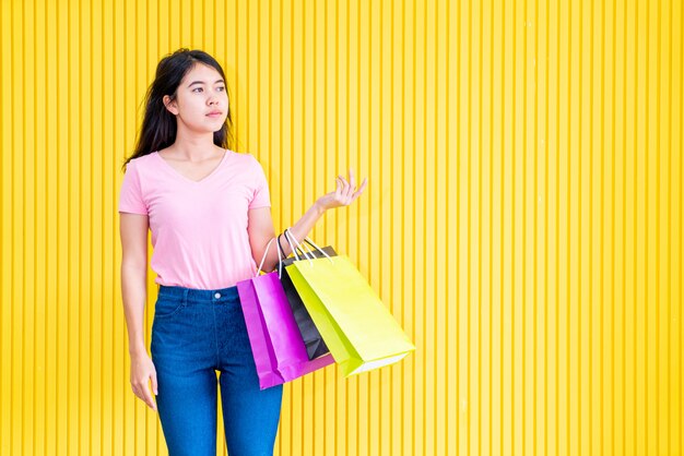 Mulher asiática, segurando sacolas de compras