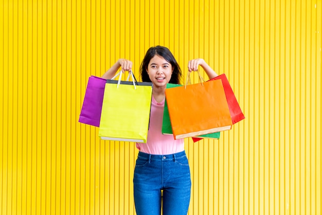 Mulher asiática, segurando sacolas de compras