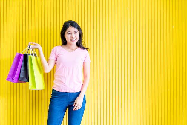 Mulher asiática, segurando sacolas de compras