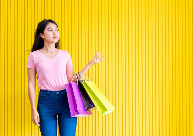 Mulher asiática, segurando sacolas de compras