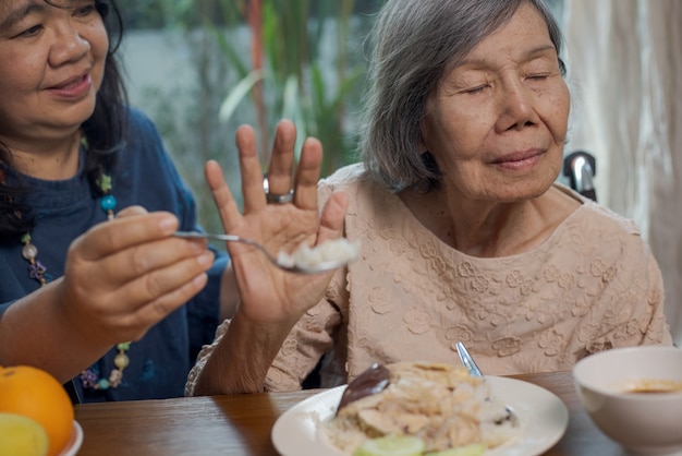 Mulher asiática sênior entediada com a comida.