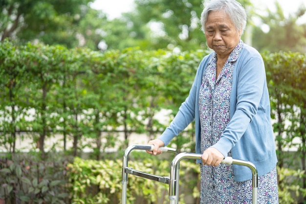 Mulher asiática sênior usa andador com forte saúde ao caminhar no parque