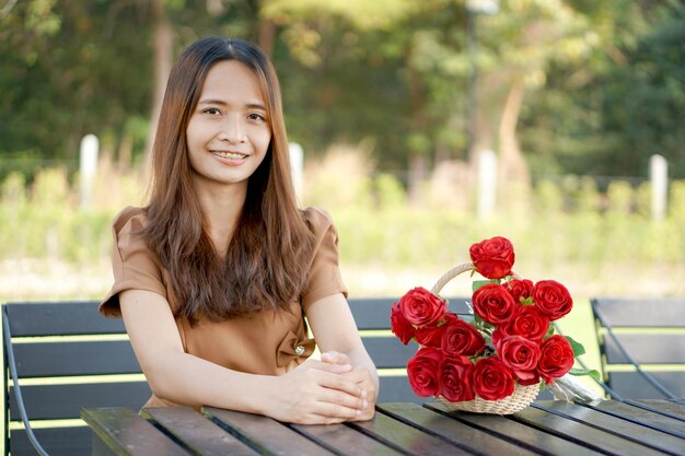 Mulher asiática sentada na mesa sorrindo alegremente