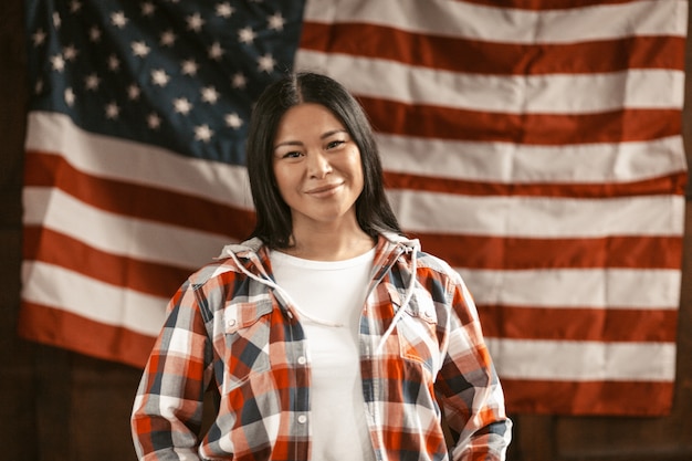 Mulher asiática sorridente na bandeira da América