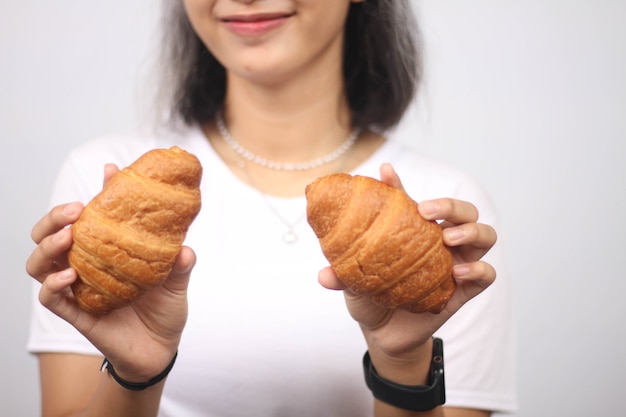 Mulher asiática sorridente segurando dois pães isolados no fundo branco