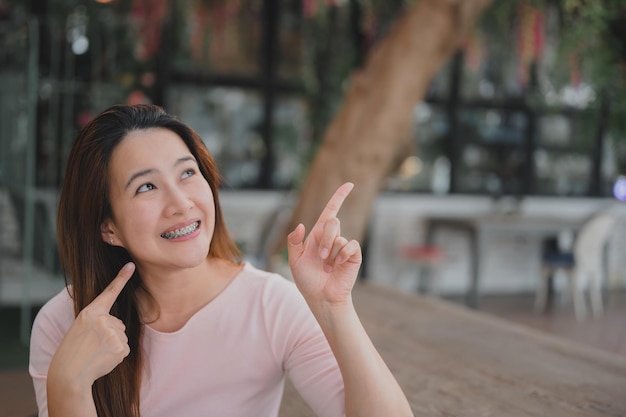 Mulher asiática sorridente usando retentor ortodôntico. cuidados dentários e dentes saudáveis.