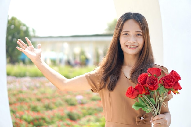 Mulher asiática sorrindo alegremente entre lindas flores