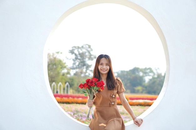 Mulher asiática sorrindo alegremente entre lindas flores