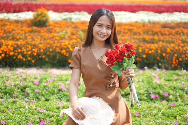 Mulher asiática sorrindo alegremente entre lindas flores