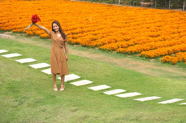 Mulher asiática sorrindo alegremente entre lindas flores