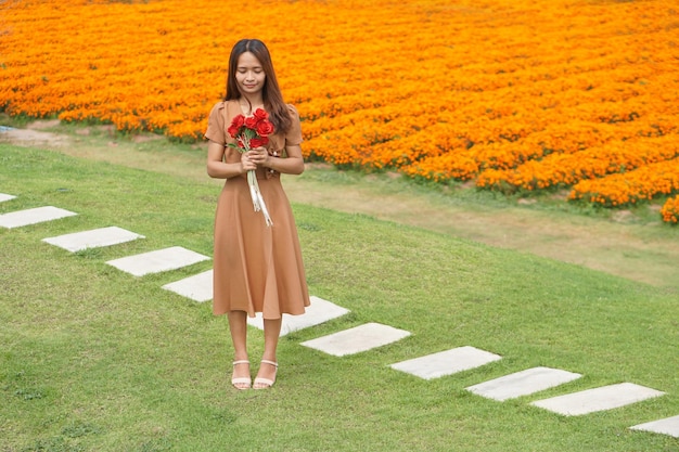 Mulher asiática sorrindo alegremente entre lindas flores