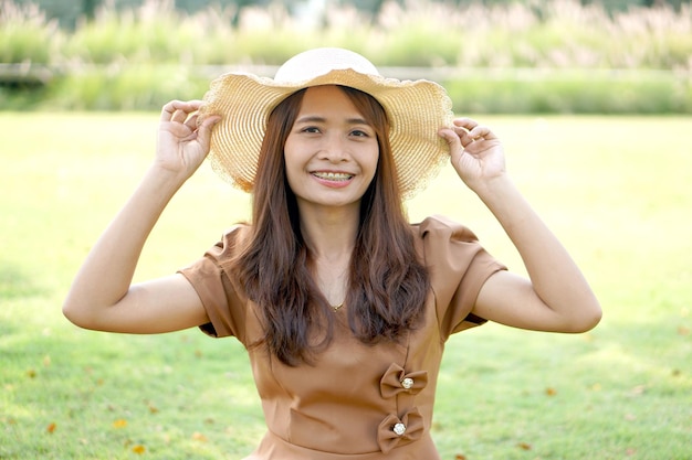 Mulher asiática sorrindo alegremente fundo de grama verde