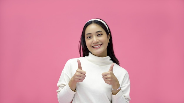 Mulher asiática sorrindo e dando polegares para cima com alegria e emoção