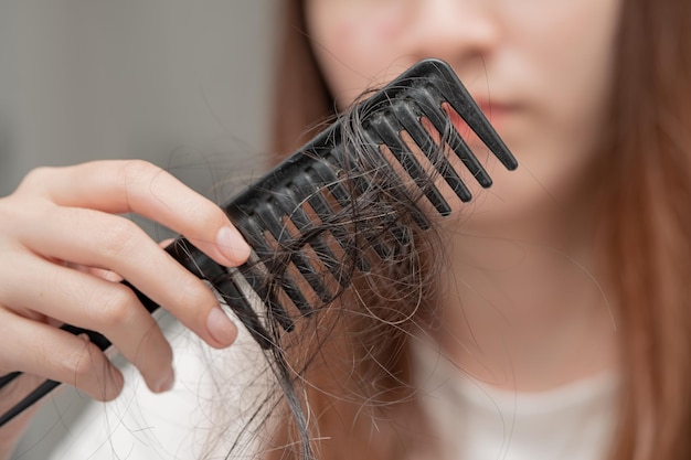 Mulher asiática tem problema com queda de cabelo longa anexada à escova de pente