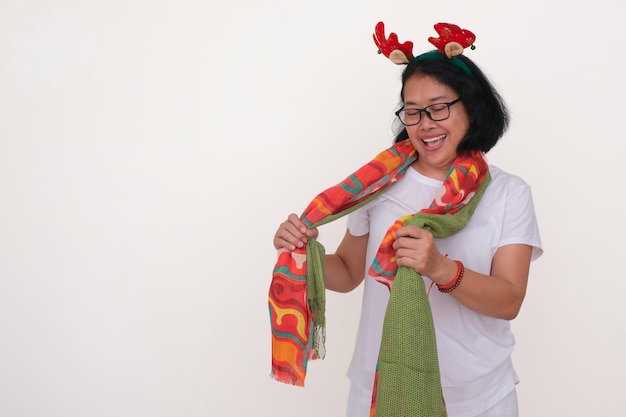 Mulher asiática tentando misturar e combinar seu lenço colorido para a festa de Natal